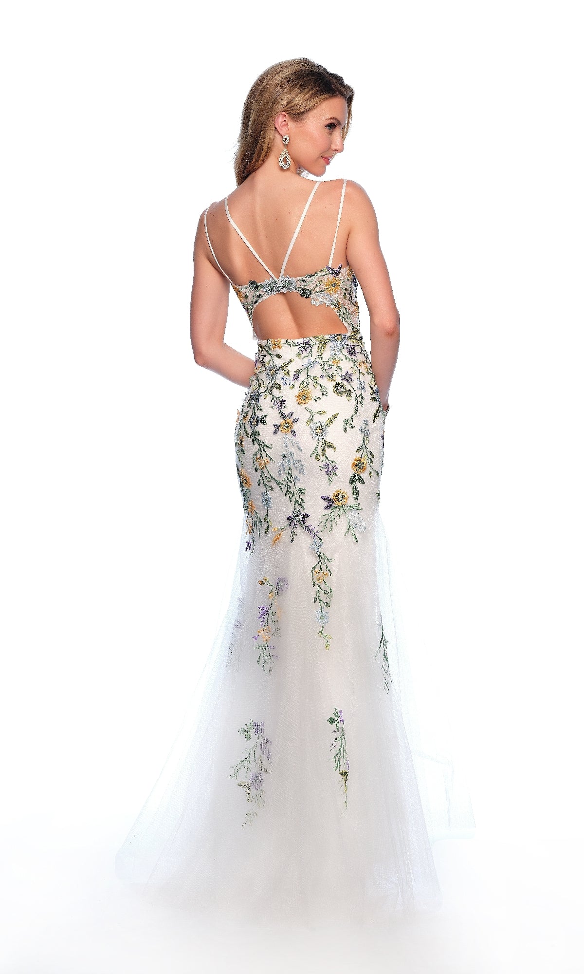 A woman stands against a white background wearing the Dave & Johnny 12016, a long white prom dress featuring floral embroidery, thin straps, a floor-length mermaid silhouette, and an open back cutout.